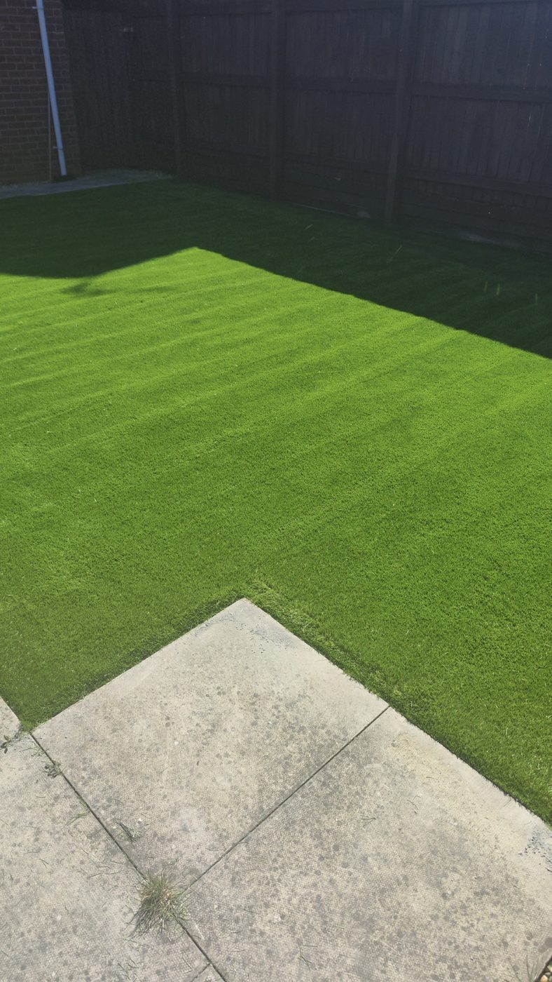 Artificial grass meeting concrete paving slabs with a tight, level edge
