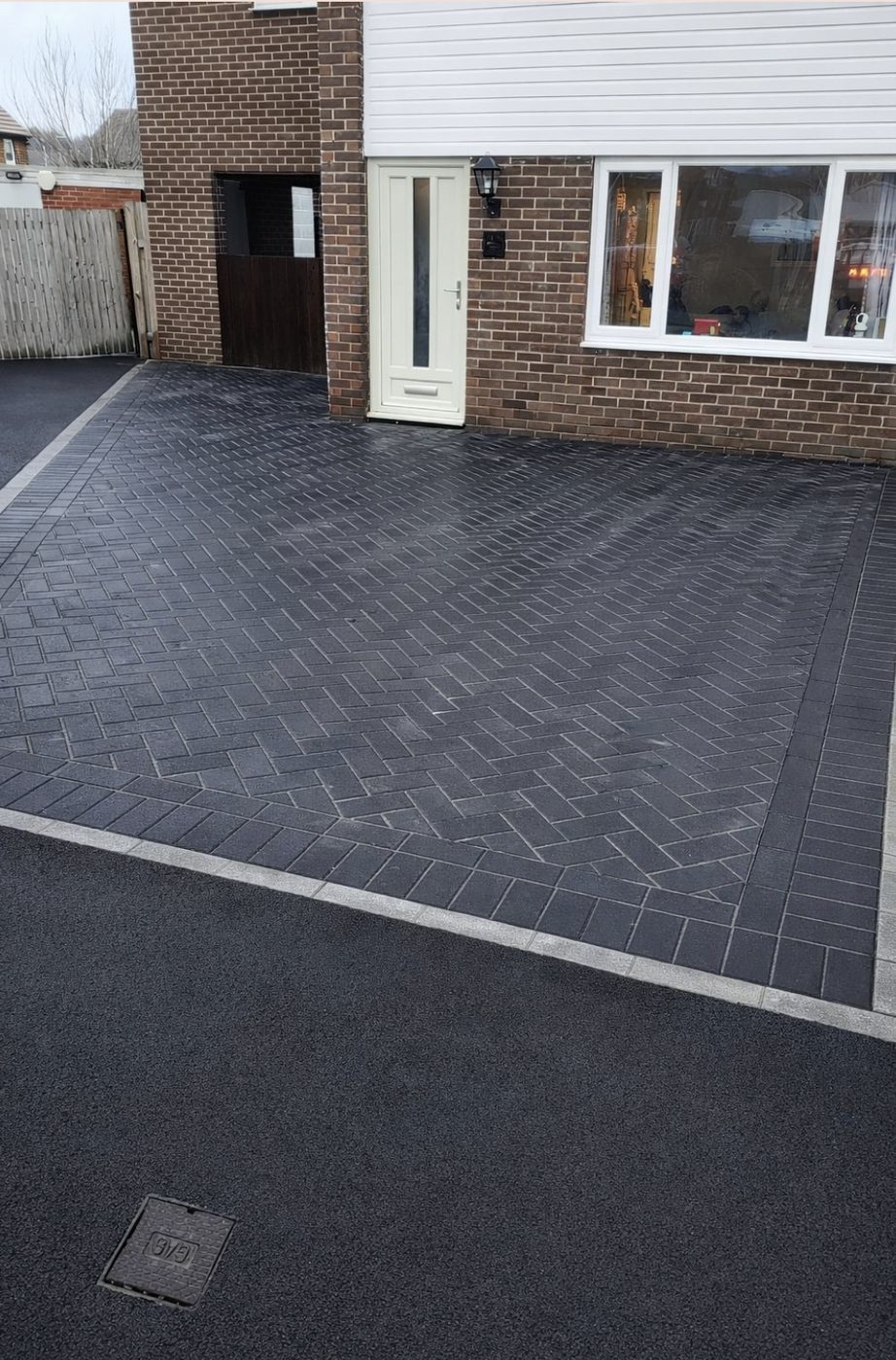 Charcoal block paved driveway in herringbone with a light border