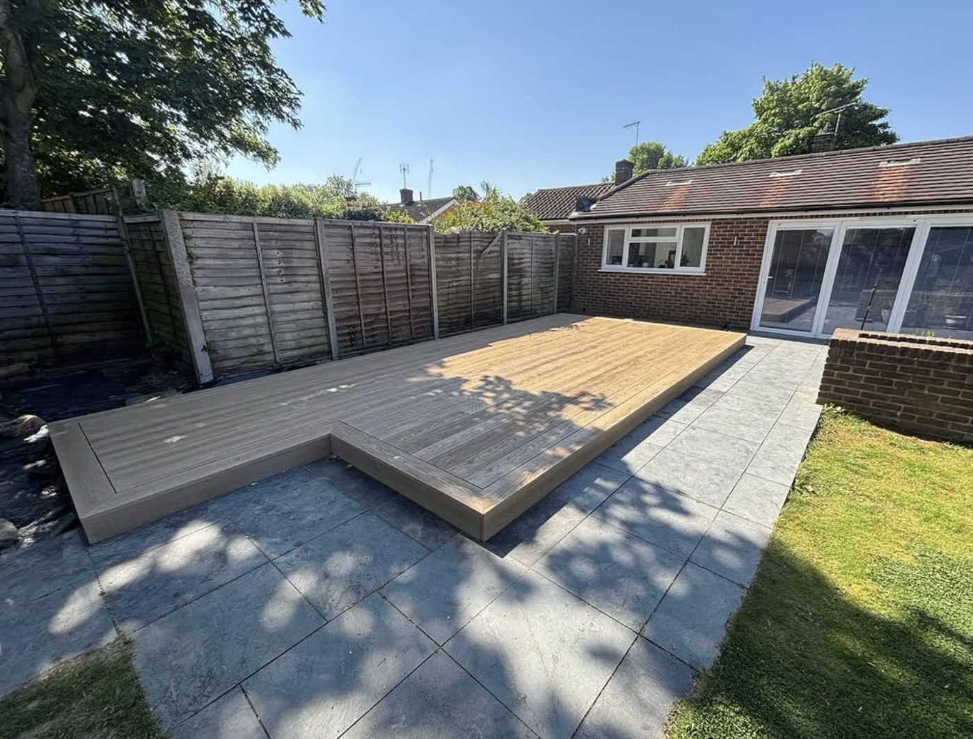 Composite deck stepping down to a grey porcelain patio