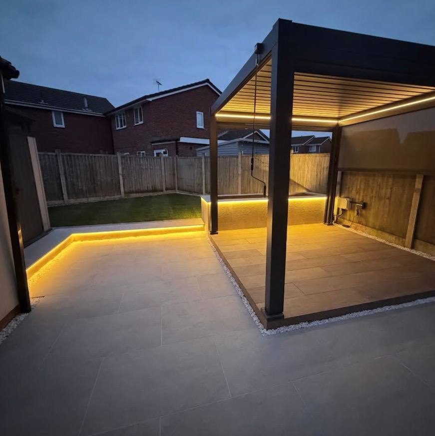 Aluminium pergola and patio lit with warm strip lighting at dusk