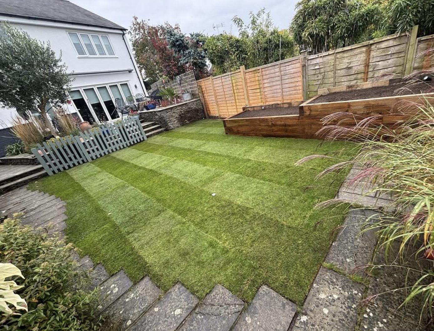 Stepped garden with timber sleeper raised beds and stone steps